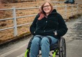 Helen sat in her wheelchair on a small bridge. This bridge crosses the stream and is a lovely spot.