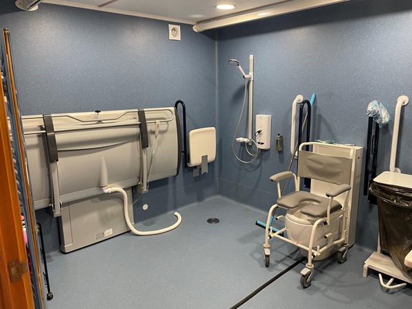 Wet room showing level-access shower, adult changing bed and Clos-o-Mat toilet (wheeled shower chair not included)