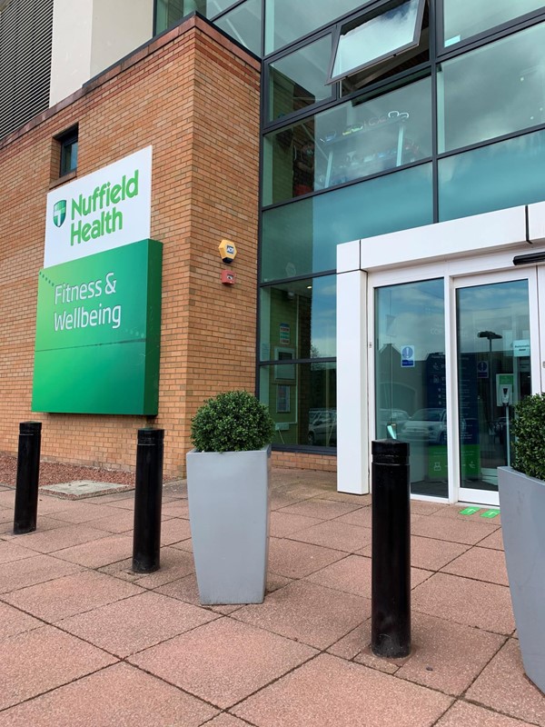 Outside of Nuffield Health Edinburgh. There are bollards and plants outside the door.