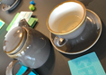 Good games and drinks. Pic shows grey teapot with matching cup abs saucer. Cards and dice from the game Chameleon are scattered around.