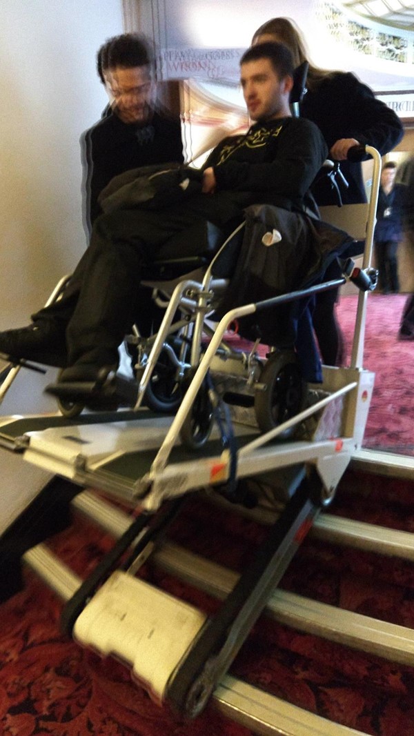 Stair climber being used. The figure in the chair is me and the staff pictured have given consent to use all attached photos