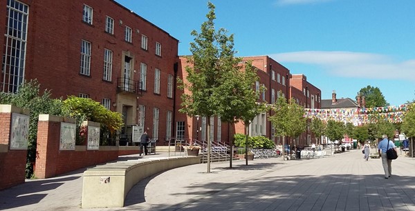 Entrance to the University of Leeds Student Union; there is an accessible entrance to the right of the picture, with a large pedestrianised pathway and trees outside the Union