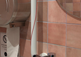 Image of red cord wrapped around grabrail at the sink.