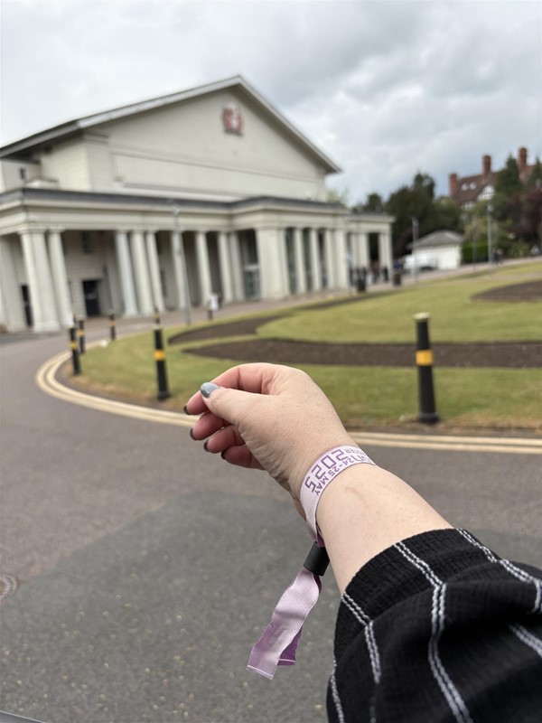 Image of a hand and De Monfort Hall