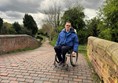 Image of Paul sitting on a stone bridge.