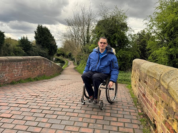 Image of Paul sitting on a stone bridge.