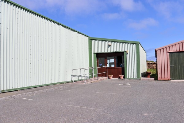 Entrance with shallow ramp to main door. One blue badge space in car park is by the door.