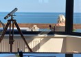 Telescope in conservatory. Friend sat on terrace.
