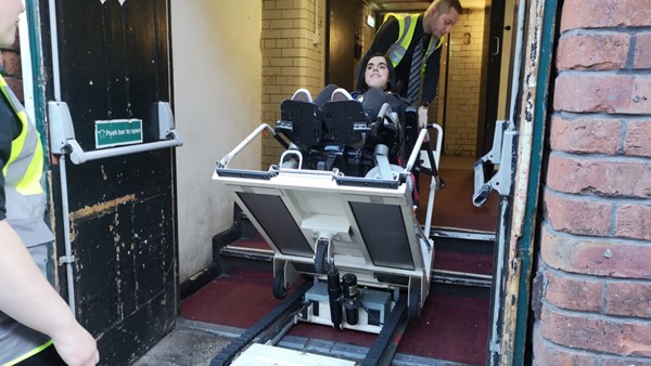 Wheelchair user entering the venue via a stair climber.