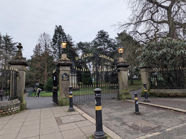 Image of entrance to the park, stone entry ways with black and gold fenching with the wording Botanic Gardens above.
