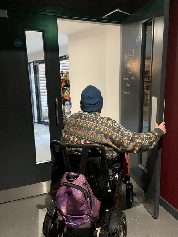 Image of a wheelchair user going through inward opening double doors