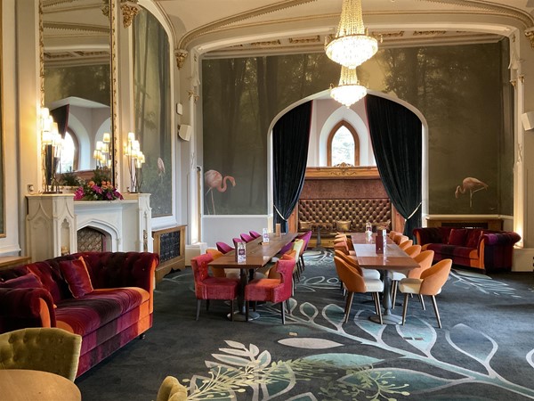 GARDEN ROOM. Directly opposite The Oak room, you will enter the nicely decorated “Garden Room” this is a very interesting quiet place to enjoy reading your favourite book of the day, while relaxing in one of its softly cushioned sofas or a high backed chair. Each wall is lined with Flamingoes either in wooden frames, or as a wallpaper wall. It is a pleasant escape, worth going to see. The soft lightening hints of gold, lovely chandeliers highlight its historical period, and the carpet has been selected well to bring to life the whole room.