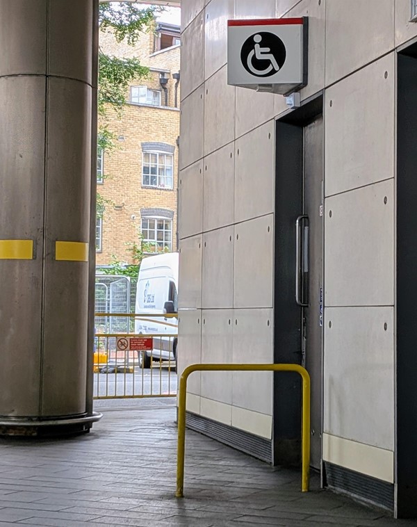 Image of accessible toilet door from the outside with wheelchair symbol above it