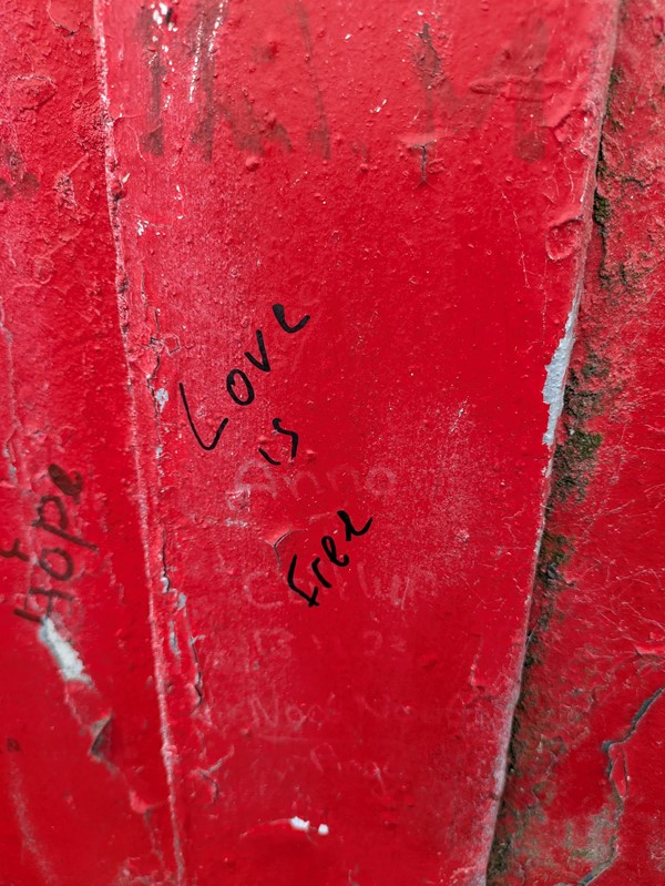Image of writing on the wall reading Love is Free