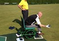 Photo of a wheelchair user bowling.