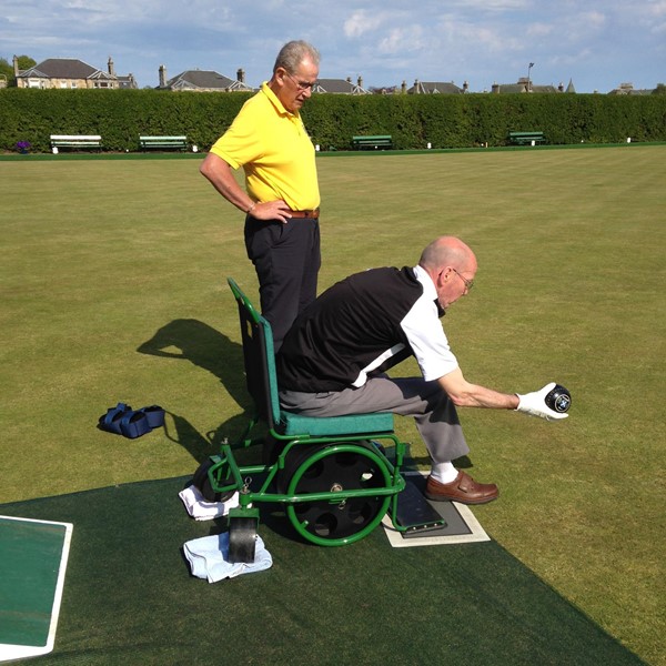 Photo of a wheelchair user bowling.