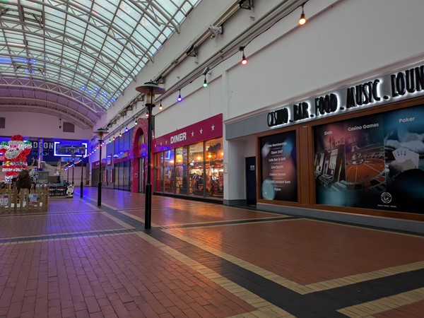 Image of Red Dragon Centre interior, there's a bowling alley and Diner, and a bar. The building has a glass-domed ceiling