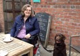 Picture of a lady in a powerchair, with a brown laborador, at Bute Park