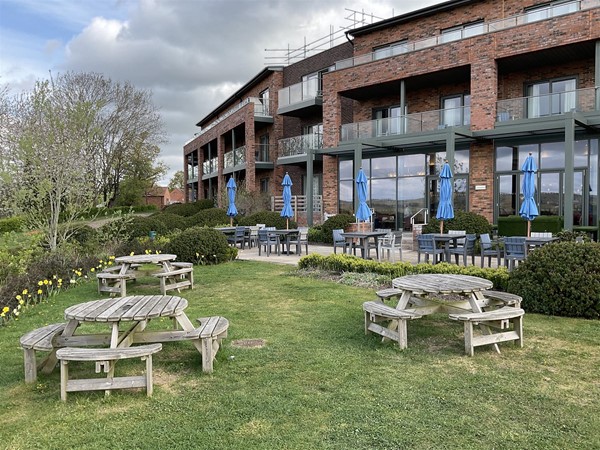 Image of a building and picnic benches