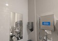 Image of the accessible toilet showing the sink, wastebins, mirror and hand dryer