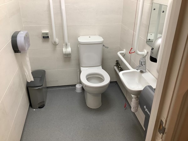(18) small but spotlessly clean toilet, with lots of grab rails