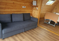 Image of the living room area of the accessible glamping pod including the pull out sofa bed.
