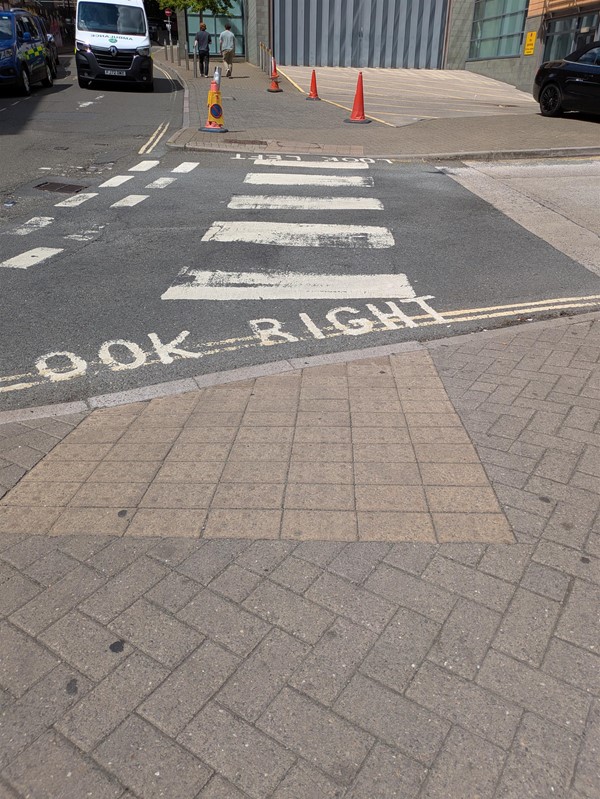 Image of a zebra crossing at the station, there are dropped kerbs and tactile paving