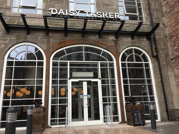 Image of the entrance to Daisy Taskers showing the set of automatic double doors outlined white.