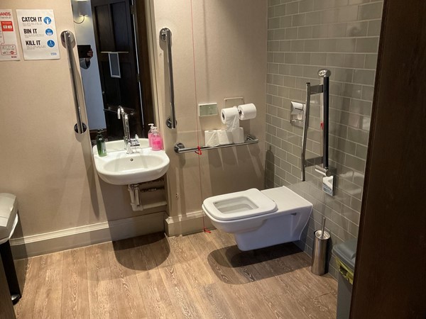 Spacious disabled toilet, grab rails and pull cord, spotlessly clean