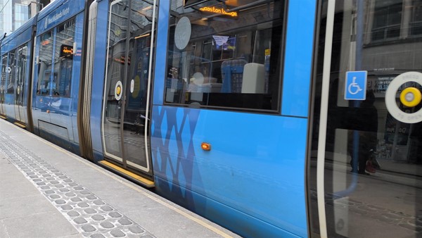 Image of tram at the tram stop, there's tactile paving at the edge