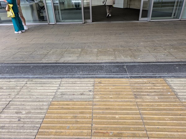 Image of  tactile paving on the steps on the way in to the bus station