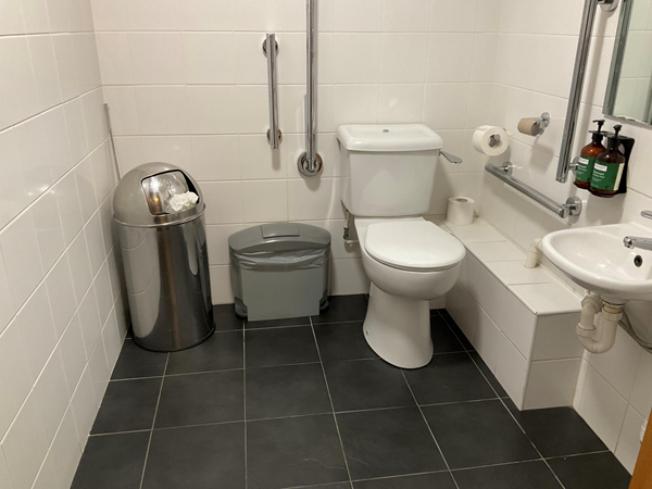 Plenty of room in the toilet, spotlessly clean. Grab rails are there to support you