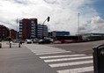 Image of a street with cars and buildings in the background