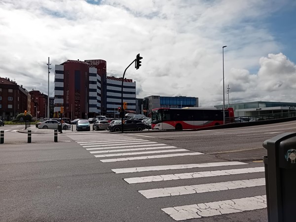 Image of a street with cars and buildings in the background