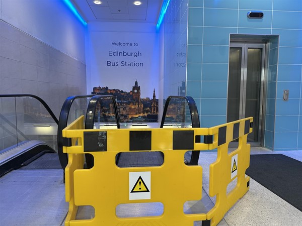 Image of one working escalator, one broken escalator and a lift
