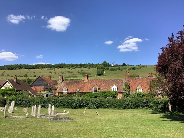 Picture of a graveyard with red brick houses behind it
