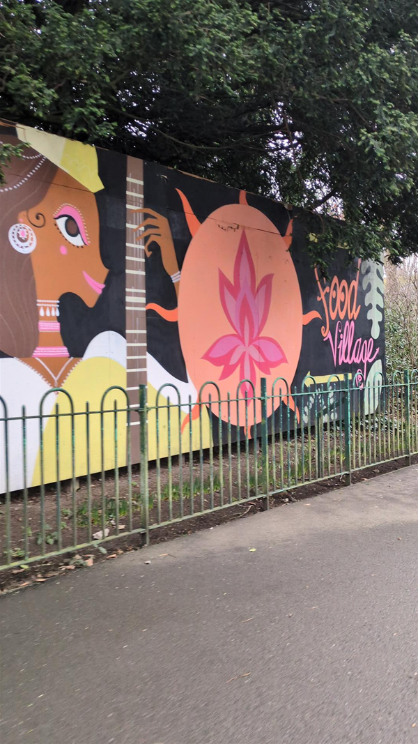 Image of mural of a dark skinned lady playing a guitar and a lotus symbol.
