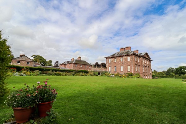 Back of the house with expansive lawned gardens.