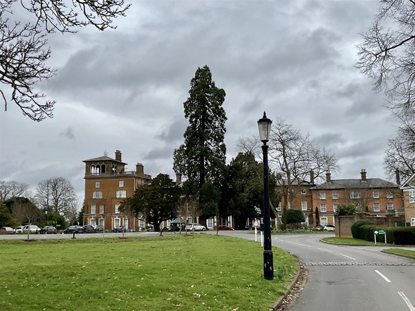 Image of a red stone building behind trees