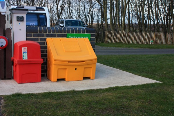 Path to elsan point, now partially blocked by fire and grit bins. You would have to wheel over the grass which is tricky with a toilet casette on your lap.