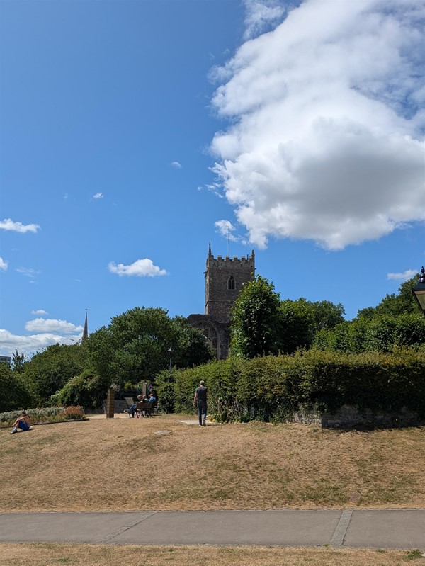 Image of of a path within the park witha tall tower in background