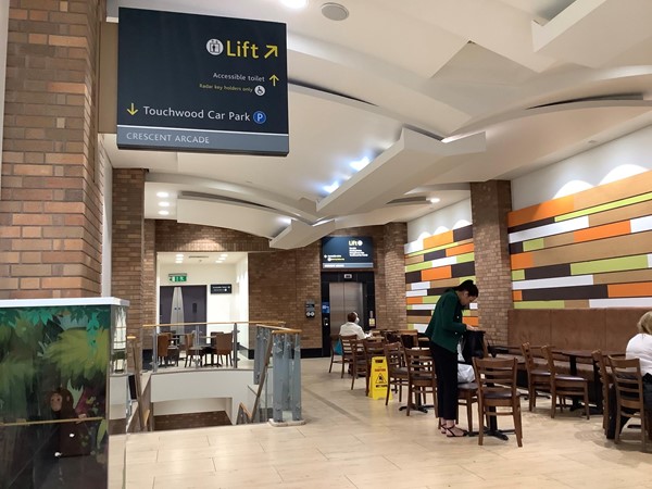 Picture of a cafe seating area with a sign for the car park