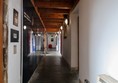 Upper corridor with exhibtion on the left and doors on the right.