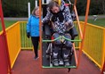 Picture of someone using the wheelchair accessible swing