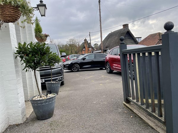 Image of a carpark and a grey fence.
