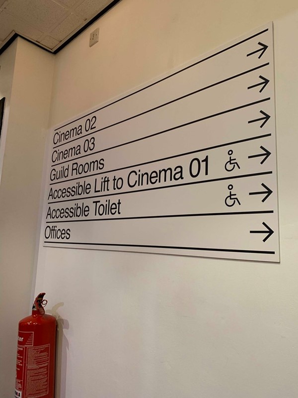 Image of large signs near reception that tell you where the lifts, toilets and offices are