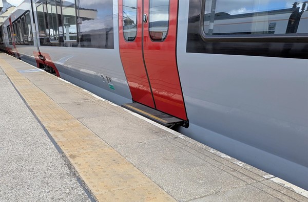 Image of platform with train at the platform and tactile paving