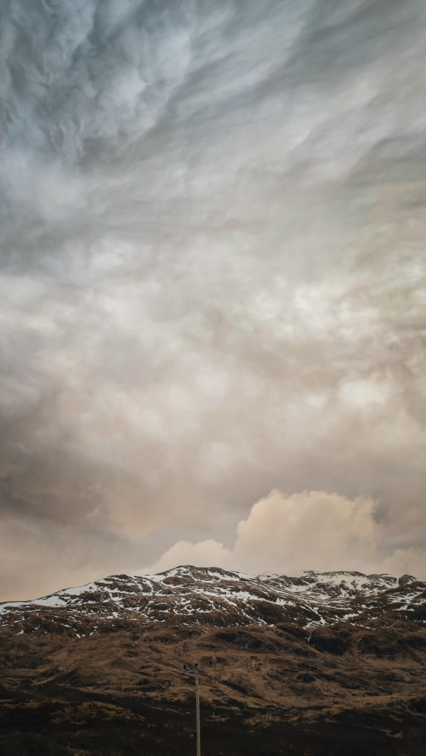 A snowy hill beneath a dramatic moody sky. This is easily seen from where you park your car. More of Ben Lawers can be seen too, if it isn't so cloudy!