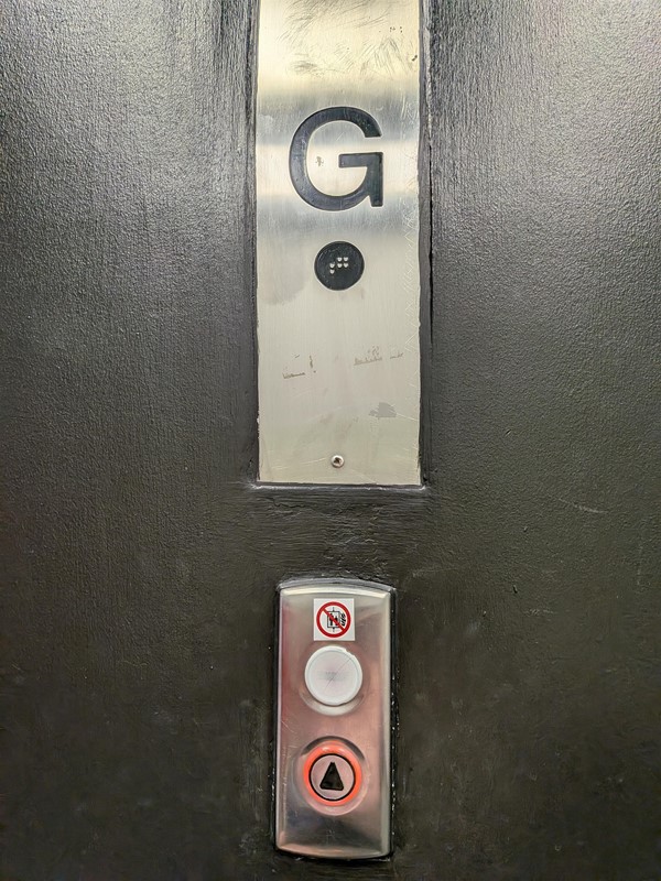 image of the level sign and lift call button on ground floor