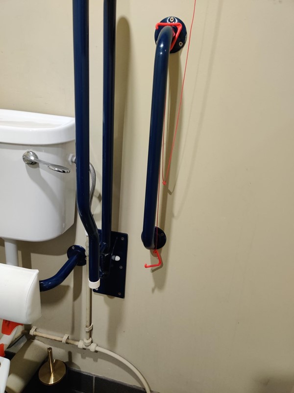 Red emergency cord tied up around a grabrail
